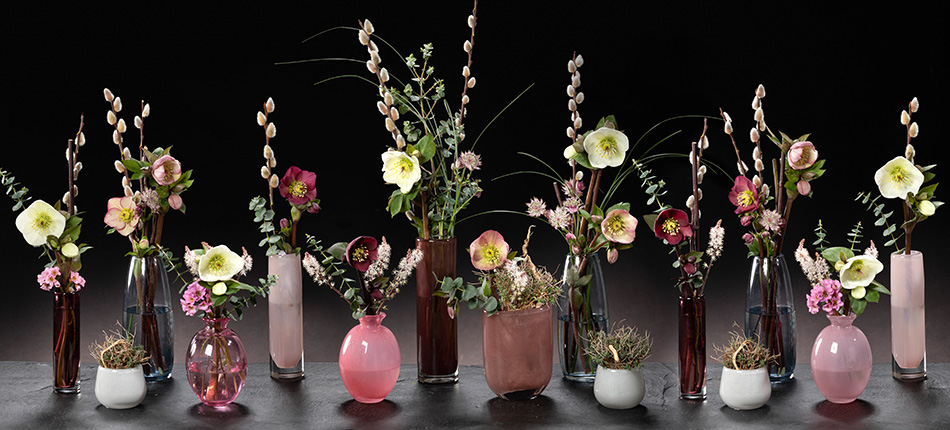 Verspielte Tischdekoration mit Aarendelle Blüten in Glasvasen in verschiedenen Formen und Farben.